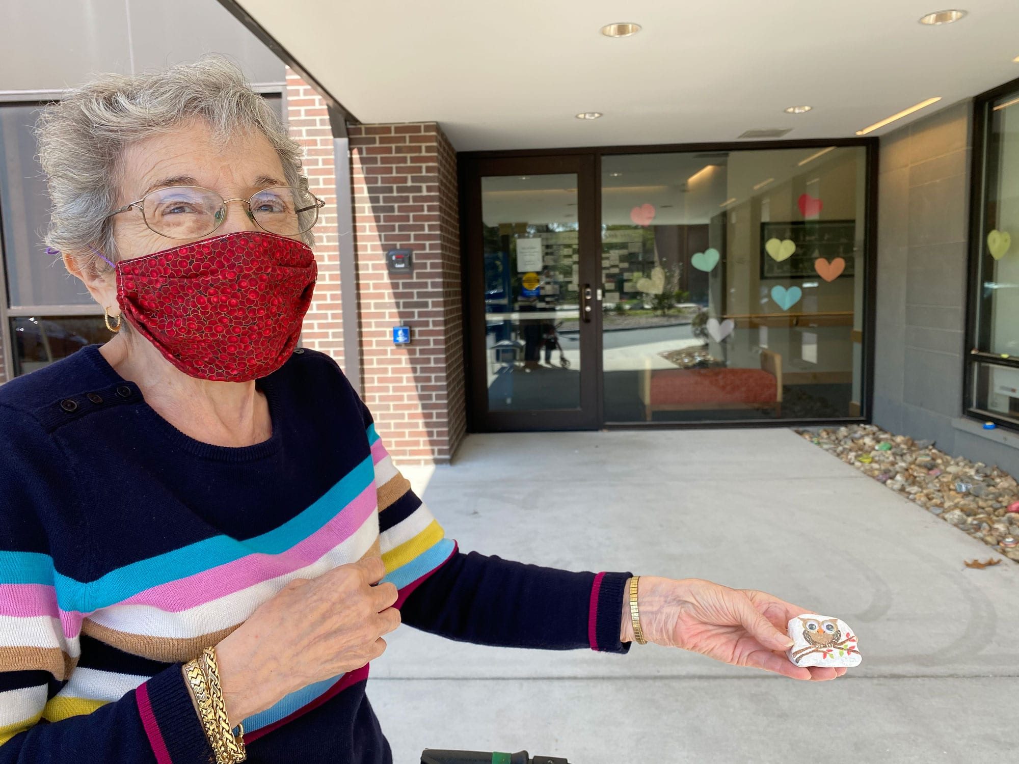 Janice Lawrence at Sosin holding a rock with an oil painted on it.