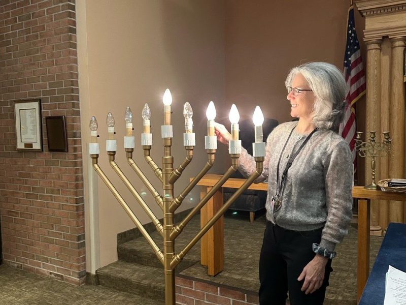 Susan Halpern lighting Hanukkah candles at JNH