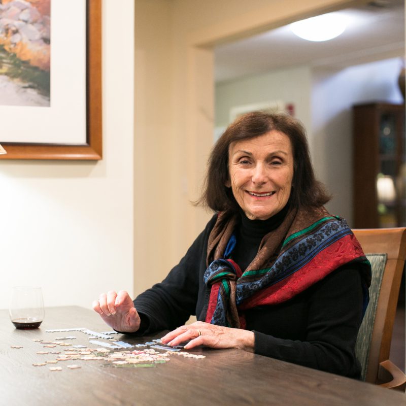 A happy female resident putting a puzzle together