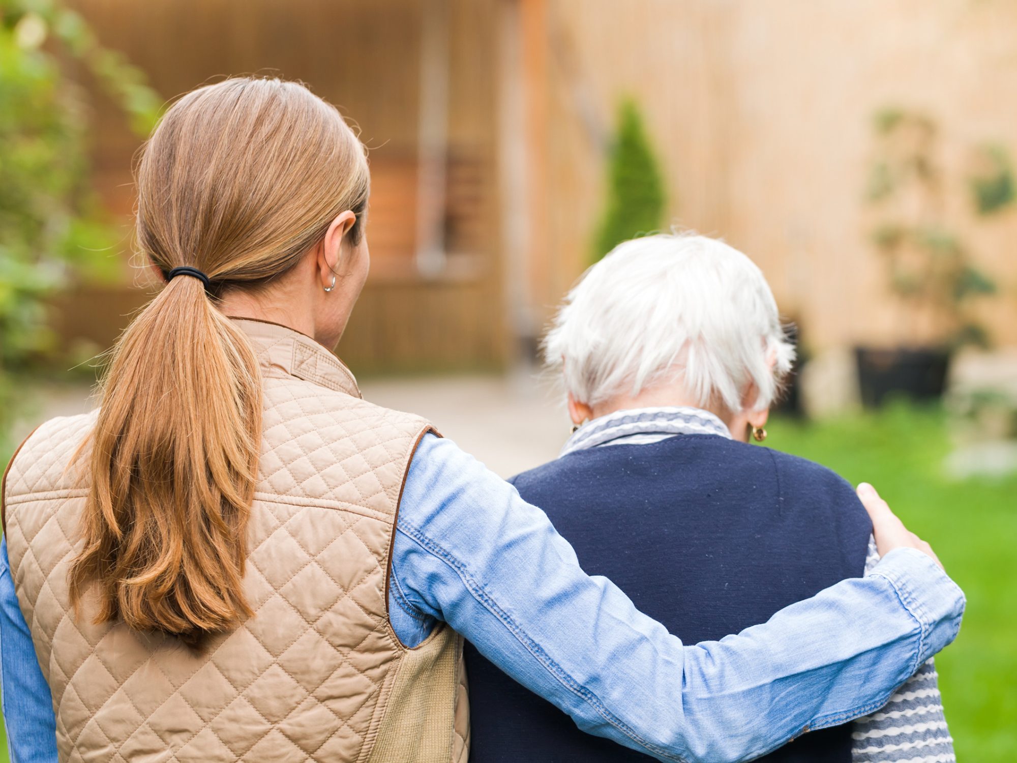 A caregiver walking with an older woman.