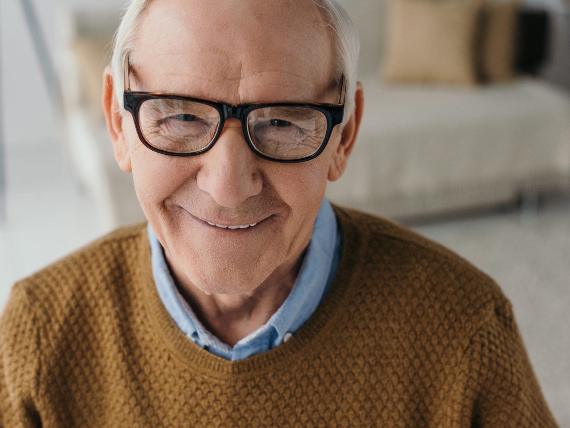 A close up portrait of an older man wearing glasses.